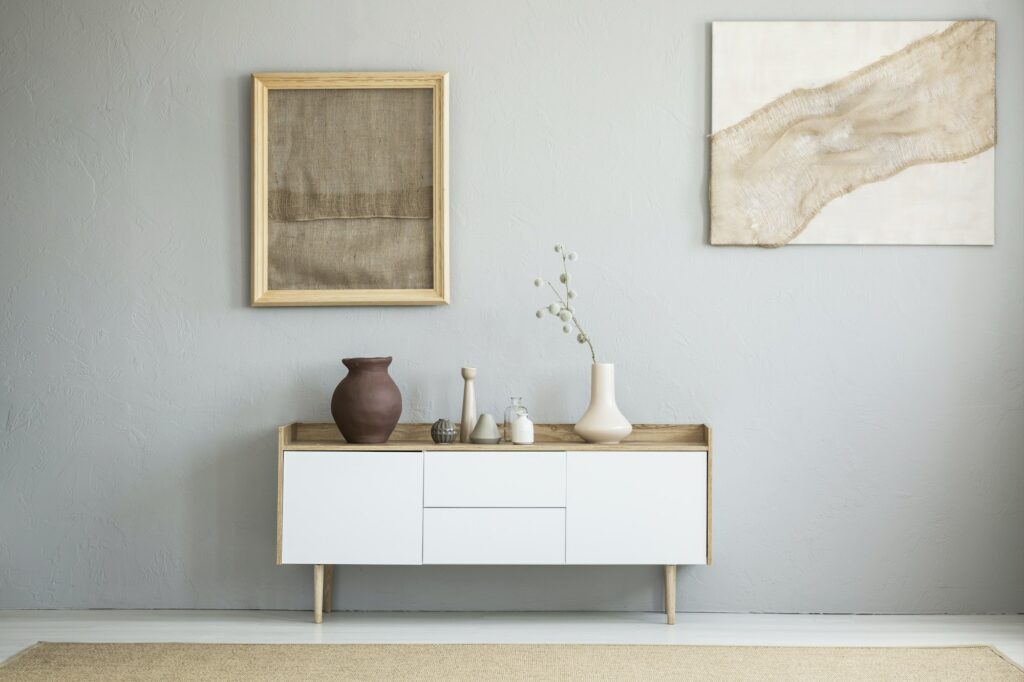 Front view of burlap artworks on a light gray wall above a woode